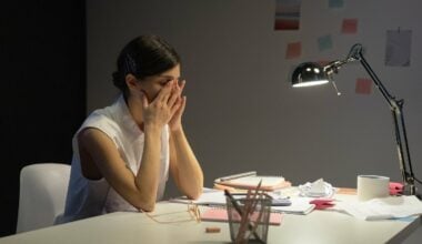 woman sitting at desk with head in hands