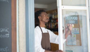 person-hanging-closed-sign-on-store-door