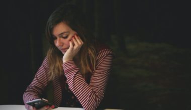 woman slouching to scroll through her phone