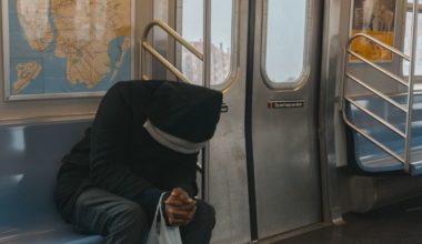 Man in black hoodie riding the subway